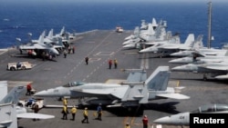 Foto de Archivo - El personal de la Armada estadounidense se prepara para lanzar un avión de combate F18 en la cubierta del USS Carl Vinson durante un ejercicio de rutina en el Mar de China Meridional, 3 de marzo de 2017.