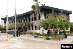 FILE - The electoral commission building after a suicide attack in Tripoli, Libya, May 2, 2018.