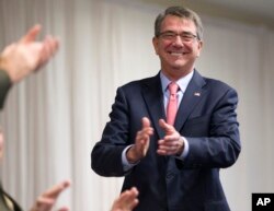 El secretario de Defensa Ash Carter aplaude al saliente director del Comando Sur, general John Kelly, en la ceremonia de cambio de mando, en Miami. Enero 14, 2016.