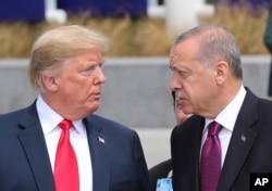 FILE - President Donald Trump, left, talks to Turkish President Recep Tayyip Erdogan as they tour the new NATO headquarters in Brussels, Belgium, July 11, 2018.