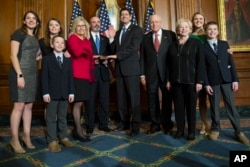 Liz Cheney acompañada de su familia es juramentada como legisladora de Wyoming, por el presidente de la Cámara de Representantes Paul Ryan. Enero 3 de 2017.