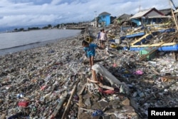 Los residentes caminan entre los escombros después del tsunami en Labuan en Pandeglang, provincia de Banten, Indonesia, 26 de diciembre de 2018.