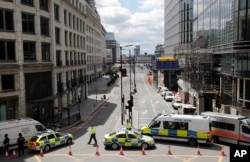Camionetas y autos de la policía bloquean el acceso a una avenida luego del ataque en el Puente de Londres.