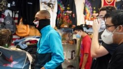 Los clientes y empleados de la tienda de ropa Petty Cash, en Houston, Texas, usan máscaras cuando los restaurantes y las tiendas vuelven a abrir después del levantamiento de algunas restricciones para prevenir la propagación de la enfermedad por coronavirus (COVID-19). Primero de mayo de 2020.