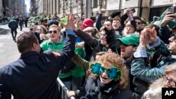 Un bombero de la ciudad de Nueva York es saludado por el gobernador del estado Andrew Cuomo durante el desfile del Día de San Patricio, el sábado, 17 de marzo de 2018.