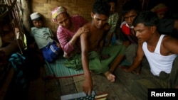 လူမှောင်ခိုကုန်ကူးခံရသူတွေလက်ထဲက မြန်မာ့ရေတပ်မတော်က ကယ်တင်ထားတဲ့ အဘ္ဘဒူလာမင်က စစ်တွေ ဒုက္ခသည်စခန်းအတွင်းမှာ သူမှတ်မိတဲ့သူတွေကို ညွှန်ပြေနေစဉ်။