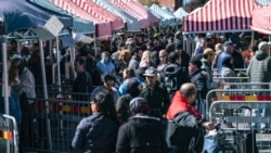 La gente hace cola detrás de las barreras para reducir la congestión en los puestos en Mollevangstorget, en Malmo, Suecia, el sábado 25 de abril de 2020, en un intento por frenar la propagación del coronavirus.