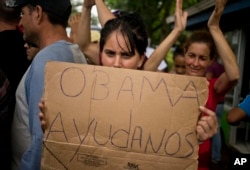 Una inmigrante cubana pide ayuda al presidente Barack Obama durante una protesta en Nicaragua. Nov. 16, 2015.
