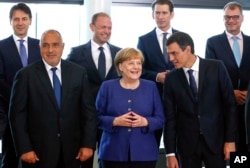 La canciller alemana Angela Merkel (centro), habla con el primer ministro español, Pedro Sánchez, mientras posan para una foto grupal en una cumbre informal de la UE sobre migración en la sede de la UE en Bruselas, el domingo 24 de junio de 2018. (Yves Herman, Pool Photo vía AP).