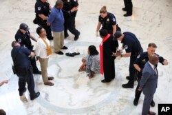 Un grupo de estadounidenses son arrestados por la Policía del Capitolio por demorar una audiencia del Congreso sobre una iniciativa republicana de salud que recortaría la cobertura médica a millones. Sept. 25, 2017.