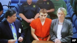 Un monitor de video muestra al sospechoso del tiroteo en la escuela Nikolas Cruz (C) ante la juez Kim Theresa Mollica en la corte del condado de Broward, el jueves 15 de febrero de 2018 en Fort Lauderdale, Florida.