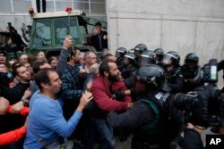 Guardias civiles alejan a la gente de la entrada de un centro deportivo donde se instaló un colegio electoral para el referéndum catalán. San Julia de Ramis, cerca de Girona, España. Oct. 1, 2017.