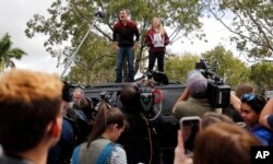 Organizadores de una protesta contra la violencia de armas, Cameron Kasky (izq.) y Jackie Corin(der.) sobreviviente del tiroteo en la escuela Marjory Stoneman Douglas de Florida, hablan a otros estudiantes antes de abordar autobuses para asistir el miércoles a la manifestación en el capitolio estatal, en Tallahassee. Feb.20 de 2018.