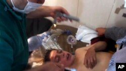 Un médico sirio tratando a un niño después de una sospecha de ataque químico.