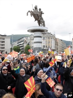 Feligreses ondean bandeas para saludar al papa Francisco a su llegada para celebrar misa en la plaza en Skopie, Macedonia del Norte, el martes, 7 de mayo de 2019.