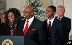 El presidente de EE.UU. Donald Trump sonríe mientras un pastor de Virginia y su familia, invitados a la Casa Blanca, hablan de los planes que tienen para el dinero que recibirán con el recorte de impuestos que el Congreso está por aprobar. Dic. 13 de 2017.