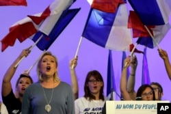 FILE - France's far-right National Front president Marine Le Pen sings the French National anthem "La Marseillaise" after her speech in Frejus, southern France, Sept. 18, 2016.