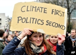 Una manifestante sostiene un cartel que dice "El clima primero, luego la política", durante una marcha en Bruselas el domingo 2 de diciembre de 2018.