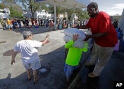 Empleados de Rose Ice and Cool Co. una empresa de Wilmington, Carolina del Norte, reparten hielo a residentes de la ciudad afectados por Florence. Septiembre 18 de 2018.