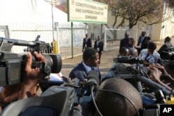 Zimbabwean President Emmerson Mnangagwa's legal representative Paul Mangwana talks to the media outside the Constitutional Court in Harare, Aug. 22, 2018.
