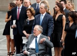 El expresidente George H.W. Bush, en silla de ruedas, su hijo el expresidente George W. Bush, y otros miembros de la familia observan mientras el ataúd de la exprimera dama Barbara Bush es colocado en un carro funeral luego de un servicio religioso en la iglesia episcopal St. Martin en Houston, Texas. Abril 21 de 2018.