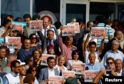 Lawmakers and press freedom activists hold copies of the Cumhuriyet newspaper during trial of 17 writers, executives and lawyers of the secularist Cumhuriyet newspaper in Silivri near Istanbul, Turkey, Sept. 11, 2017.