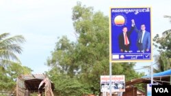 ស្លាក​សញ្ញា​គណបក្ស​សង្រ្គោះ​ជាតិ​នៅ​ក្នុង​ក្រុង​សៀមរាប​ ដែល​មាន​រូប​អតីត​ប្រធាន​គណបក្ស​ លោក សម រង្ស៊ី និង​ប្រធាន​គណបក្ស​បច្ចុប្បន្ន លោក កឹម សុខា។ (ស៊ុន ណារិន/VOA)
