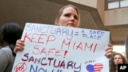 Manifestante tiene un cartel durante una manifestación en el centro de Miami. El alcalde del condado de Miami-Dade, Carlos Gimenez, emitió una orden asegurando a la administración Trump que Miami-Dade no está funcionando como una ciudad santuario para inmigrantes ilegales.
