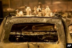 Figuras de un pesebre sobre un auto calcinado después del incendio Camp Fire, en Pearson Road, el lunes 12 de noviembre de 2018, en Paradise, California (Foto AP / Noah Berger)