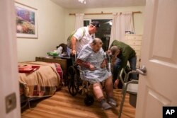 Henry Provencher, de 87 años, es ayudado por su hijo y otra persona para evacuar la residencia de cuidado médico donde es atendido en Santa Rosa, California. Sábado 26 de octubre de 2019. AP.