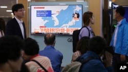 La televisión surcoreana reporta el temblor en el nordeste de Corea del Norte, según pueden ver pasajeros en la estación de trenes de Seúl.