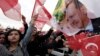Supporters wave flags as Turkey's President Recep Tayyip Erdogan delivers a speech during a rally of supporters a day after the referendum, at his palace, in Ankara, April 17, 2017.