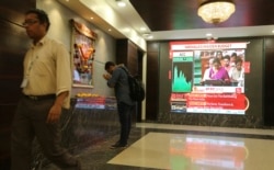 A man offers prayer to a Hindu goddess at the Bombay Stock Exchange (BSE) office, as India's Finance Minister Nirmala Sitharaman is seen on a television screen presenting the annual budget in Mumbai, India, July 5, 2019.