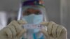 Un trabajador de la salud muestra un resultado positivo de COVID-19 durante una prueba aleatoria para los familiares del personal del ejército en el hospital de la base del ejército en Gauhati, India, el lunes 19 de octubre de 2020.