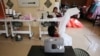 FILE - Nur Afia Qistina Zamzuri, a 9-year-old girl sews personal protective equipment (PPE) for free to medical workers working in local hospitals at her home with her mother Hasnah Hud, in Kuala Pilah, Malaysia, May 5, 2020.