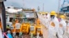 Members of a Fukushima prefecture panel, which monitors the safe decommissioning of the nuclear plant, inspect the construction site of the shore barrier, Aug. 6, 2013.