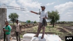 A member of the Amhara militia gives directions during a food distribution organized by the Amhara government near the village of Baker in the Tigray Region of Ethiopia, on July 11, 2021.