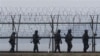 South Korean army soldiers patrol along a barbed-wire fence near the border village of the Panmunjom, in Paju, South Korea.