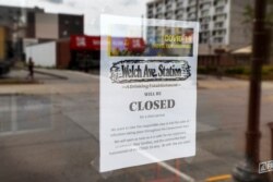 A closed sign is seen in the front window of the Welch Ave Station bar, June 23, 2020, in Ames, Iowa.