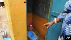 The head of the School of Motherlove Infants, Faridah Hussein Lwanga, displays Sanpants, technology used in toilets to reduce smell, as part of a campaign encouraging people to keep neighborhoods clean, in Makindye-Lukuli, Uganda, July 10, 2019.