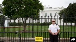 Un agente de la División Uniformada del Servicio Secreto de EE.UU. frente a una barrera temporal de la Casa Blanca. Foto de archivo. Washington, Oct. 3, 2014.