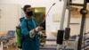 An employee from a disinfection service company wears a protective mask while sanitizing sports equipment at the gym of Benghazi Medical Center, following the outbreak of the coronavirus disease (COVID-19), in Benghazi, Libya, Aug. 6, 2020. 