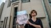 A journalist poses with a portrait of Turkish journalist Ahmet Altan, June 19, 2017, in front of the Istanbul courthouse, where his trial is to take place. 