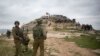 FILE - Israeli soldiers take position as Palestinian demonstrators gather during a protest against expansion of Israeli settlements, in the West Bank village of Beita near Nablus, March 2, 2020.