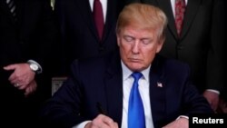 El presidente de EE. UU., Donald Trump, firma un memorando sobre aranceles de propiedad intelectual para productos de alta tecnología de China, en la Casa Blanca en Washington, DC, EE.UU., 22 de marzo de 2018.
