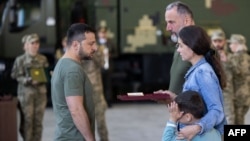 El presidente ucraniano, Volodymyr Zelenskyy, entrega una condecoración a la viuda de un teniente coronel nombrado postumamente Héroe de Ucrania, durante una reunión con funcionarios de inteligencia el 7 de septiembre de 2023.