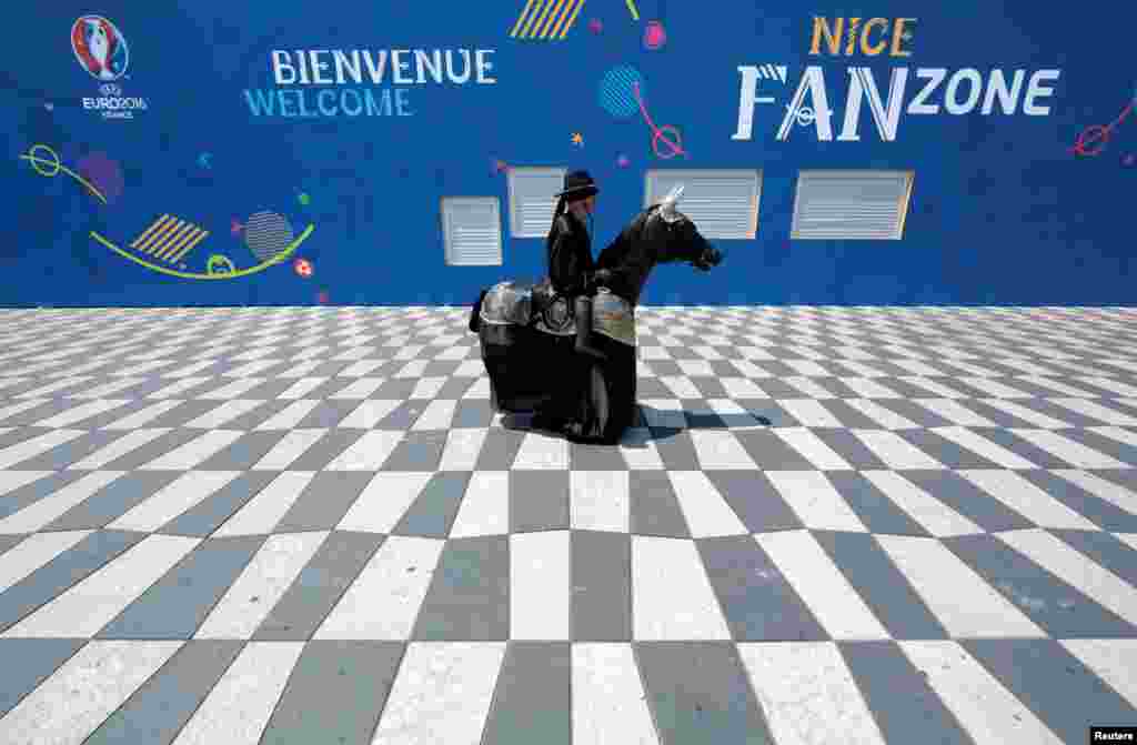 Seorang seniman jalanan mengenakan kostum &#39;Zorro&#39; menjelang pembukaan kejuaraan sepakbola Eropa 2016 di Nice, Perancis.