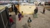 FILE - Syrian refugees, including children, stand outside their tents, in the town of Saadnayel, in the Bekaa valley, Lebanon, Jan. 22, 2016.
