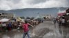 Un vendedor de escobas camina sobre una calle inundada después del paso de la tormenta tropical Isaias en Puerto Príncipe, Haití. 31 de julio de 2020.