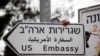 A worker hangs a road sign directing to the U.S. embassy, in the area of the U.S. consulate in Jerusalem, May 7, 2018. 